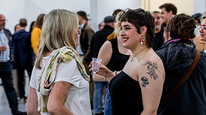 A couple of people chatting at a student event.