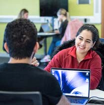 Librarian looking over a desk helping a student.