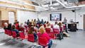 A lecturer giving a talk to a seated crowd at Glenside Campus.