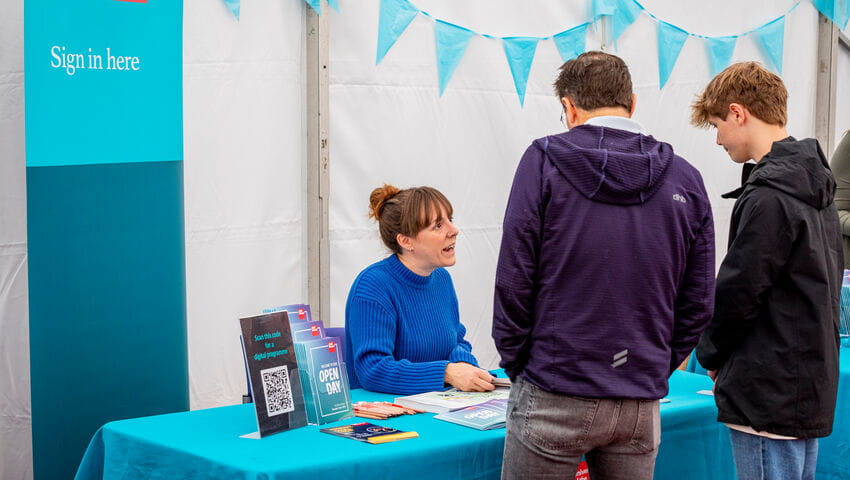 Two prospective students signing in for the Open Day at the sign in desk.