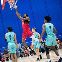A student slam dunking the basketball through the hoop