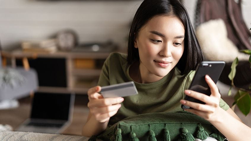 A young woman making an online purchase using a mobile phone