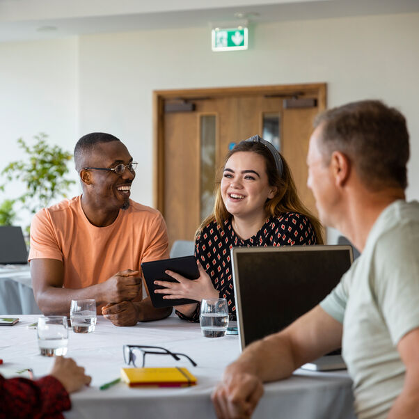 Group of researchers attending a workshop together, having a discussion around a table.