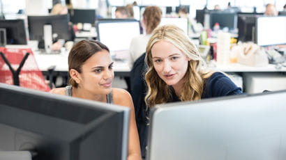 Two student look at a computer screen together.