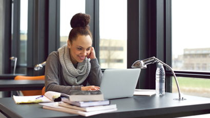 A student reading the Information Security Policies on a laptop.